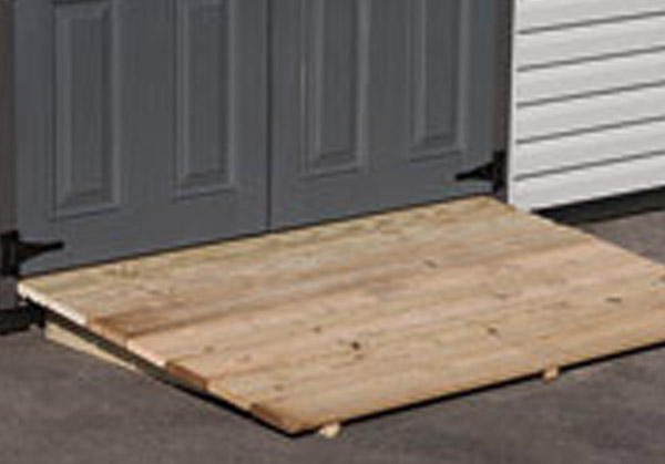 A wooden ramp that goes up to the door of a shed.